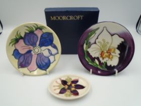 2 Moorcroft pottery pin trays - one with purple and pink anenome on a cream background, impressed