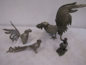 Metal fighting cocks, a pheasant and a photographer