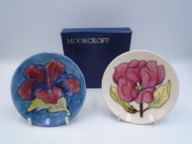 2 Moorcroft Pottery Pin Trays, one painted in the 'Hibiscus' (red) pattern on a shaded blue/green