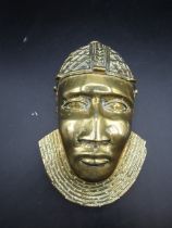 A brass  tribal mask 26cmL