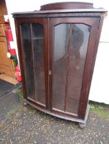 A wooden glazed display cupboard