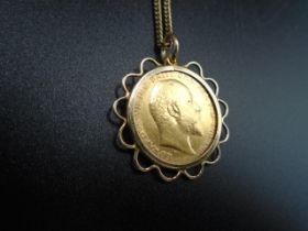 An Edward VII half sovereign (1910) set in a 9ct gold surround on a rolled gold chain. 8.36g gross