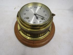 Diplex brass ships clock mounted on a wooden plinth. no key. ticking