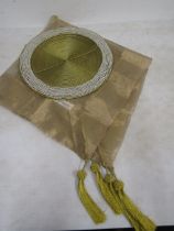 A gold organza square table cloth with a beaded charger
