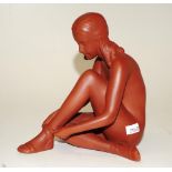 Early terracotta seated figure of a nude lady