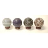 Four various semi precious hard stone balls