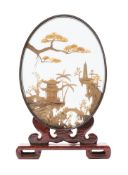 A Chinese carved diorama of oval outline depicting a pagoda landscape with bridge and cranes,
