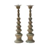 A pair of large brass pricket candlesticks with inverted bell-shaped sconces,
