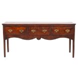 A George II elm dresser, mid 18th century; the single piece top with moulded edges,