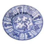 A Dutch blue and white delftware dish painted in Chinese kraak style with a lake landscape and