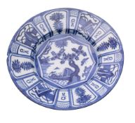 A Dutch blue and white delftware dish painted in Chinese kraak style with a lake landscape and