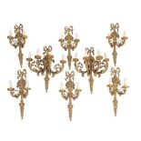 A pair of gilt brass four branch wall appliques and six matching twin-branch appligues with ribbon