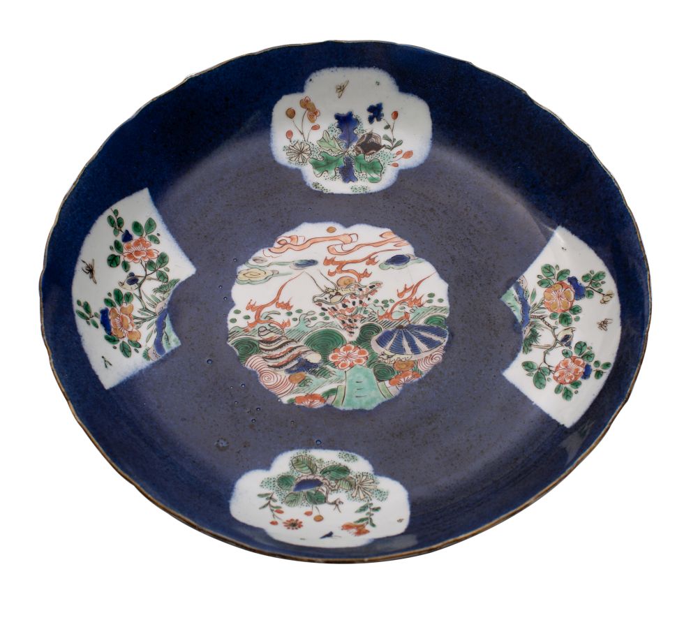 A Chinese famille verte powder-blue ground saucer dish painted with panels depicting a dragon