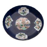 A Chinese famille verte powder-blue ground saucer dish painted with panels depicting a dragon
