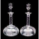 A pair of cut and engraved vine pattern glass decanters and stoppers each with compressed globular