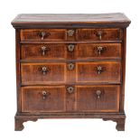 A George I oak and walnut banded chest of drawers, circa 1725.