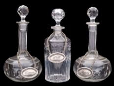 A pair of clear glass decanters and stoppers and one other,