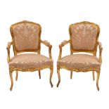 A pair of carved and giltwood and silk damask upholstered fauteuils in Louis XV style,