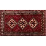 An Abadeh carpet:, the red field with triple ivory hooked medallions and all over geometric designs,