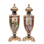 A pair of Continental porcelain triform vases and covers in the Sèvres manner each decorated with