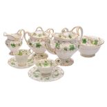 An H & R Daniel porcelain part tea service of moulded rococo form enamelled with green vines