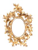 A Florentine giltwood oval wall mirror with pierced foliate frame, 32cm high.