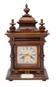 An Edwardian oak mantel clock the eight-day duration movement striking on a gong with the engraved