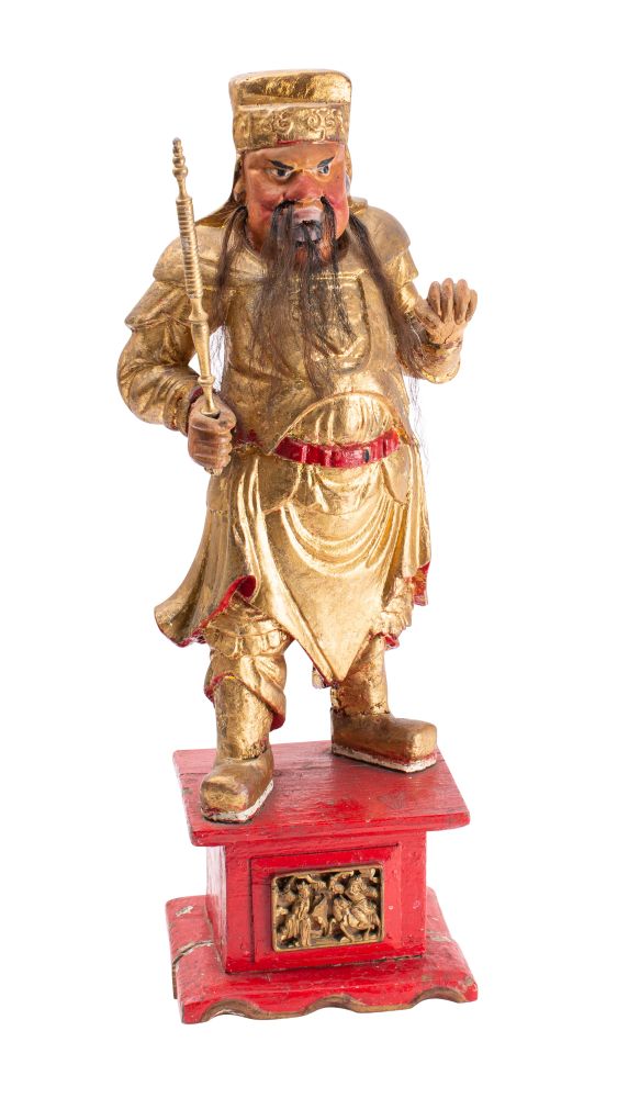 A gilt and polychrome decorated Chinese warrior figure holding a staff in his right hand,