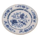 A Dutch delft charger, painted in blue with peony and prunus with further blooms on the border,