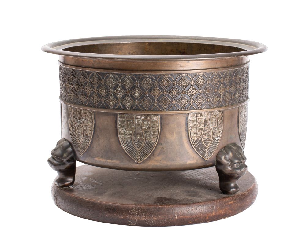 A Chinese bronze jardiniere of circular outline with banded trellis decoration with suspended