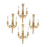 A set of four gilt-metal twin branch wall appliques with ribbon tied floral spray decorated