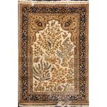 A Hereke silk prayer mat:, the ivory mihrab with a garden design of animals and birds amidst trees,