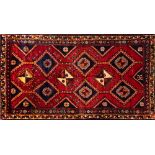 A Lori Rug, the brick red field with a design of hooked and stepped lozenge medallions,