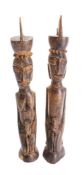 A pair of African carved wood male and female fertility figures, each with a child, 29cm high.