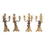 Two pairs of 19th century bronze and gilt metal three branch candelabra with foliate decorated