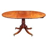 A Regency mahogany extending dining table, early 19th century; the oval top with one extra leaf,