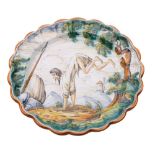 A Talavera maiolica dish decorated with a leaping bearded man in a mountainous landscape,