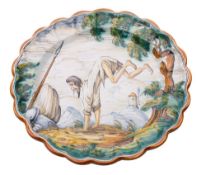 A Talavera maiolica dish decorated with a leaping bearded man in a mountainous landscape,