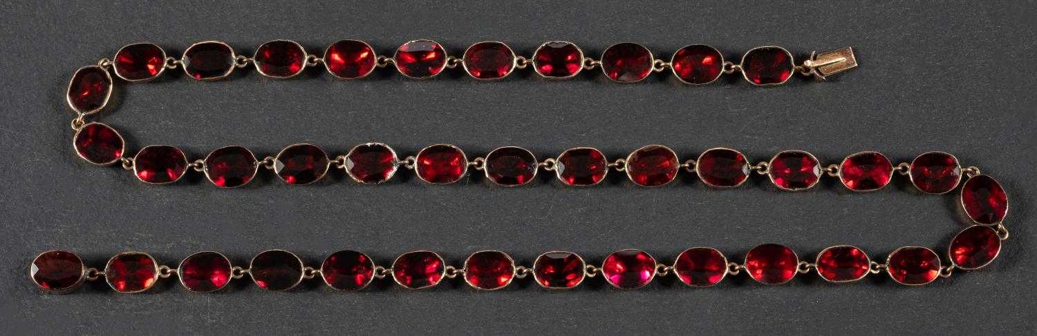 An early 19th century, oval, flat-cut, garnet, rivière necklace, with foil and closed-back,