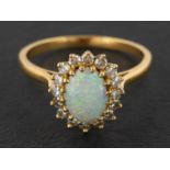 An 18ct gold, oval, cabochon-cut opal and single-cut diamond cluster ring,