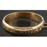 A 9ct gold hinged bangle with foliate engraving, with hallmarks for Chester, 1956,
