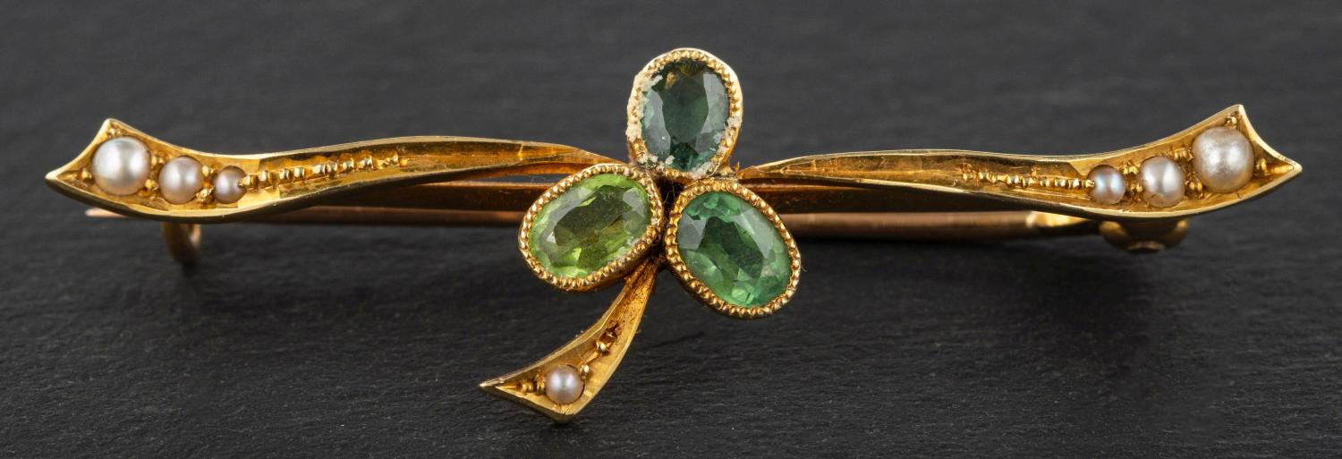 A peridot, tourmaline, emerald and seed pearl bar brooch, designed as clover leaf, stamped '15CT',