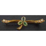 A peridot, tourmaline, emerald and seed pearl bar brooch, designed as clover leaf, stamped '15CT',