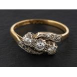 A single and round, brilliant-cut diamond cross-over ring,
