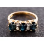 An oval, mixed-cut sapphire three-stone ring, with single-cut diamond spacers,