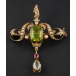 An Art Nouveau seed pearl, peridot, ruby and aquamarine pendant/ brooch,