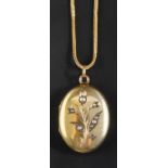 An oval locket pendant with seed pearl decoration in floral motif,