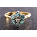 An 18ct gold, blue zircon and round, brilliant-cut diamond flower head ring,