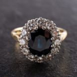 An oval, mixed-cut sapphire and round, brilliant-cut diamond cluster ring,