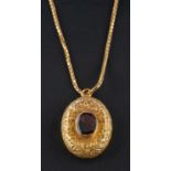 A late Victorian/ Edwardian, foiled back garnet, oval locket pendant,